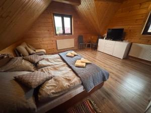 a bedroom with a large bed in a wooden cabin at Chalupa u Jožka in Betlanovce