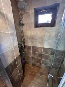 a bathroom with a shower with a window at Chalupa u Jožka in Betlanovce +7 photos