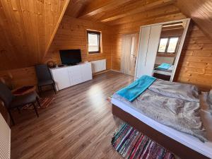 a bedroom with a bed and a desk in a cabin at Chalupa u Jožka in Betlanovce