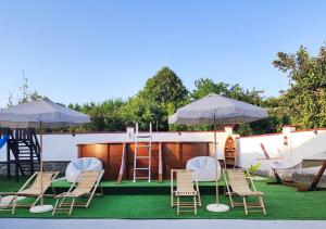 a group of chairs and umbrellas on a lawn at Guest House - Heaven in Byala