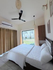 a bedroom with a white bed and a window at LAGUNA BLU beach villa in Irimbranallūr +24 photos