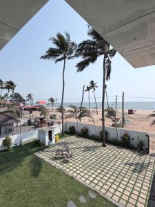 a view of the beach from the balcony of a house at LAGUNA BLU beach villa in Irimbranallūr