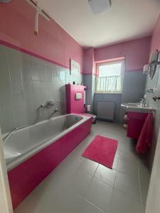 a pink bathroom with a tub and a sink at Ferienwohnung Kirschtraum in Mülheim-Kärlich +31 photos