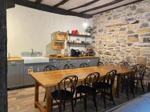 a kitchen with a wooden table and chairs in a room at Casa Rural Donamariako Benta in Donamaría