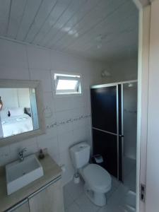 a bathroom with a toilet and a sink and a shower at Pousada Landhaus in Urubici