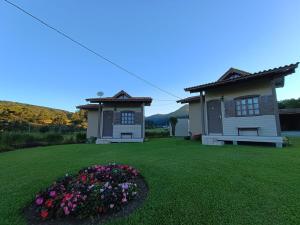 a house with a yard with flowers in front of it at Pousada Landhaus in Urubici +29 photos
