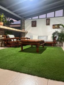 a patio with two benches and a green lawn at Cactus & Cove Villa in Santa Cruz