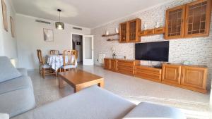 a living room with a couch and a tv at Casa García in L'Aldea
