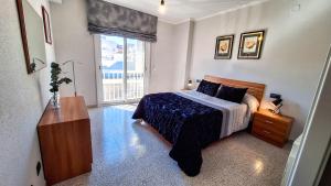 a bedroom with a bed and a dresser and a window at Casa García in L'Aldea
