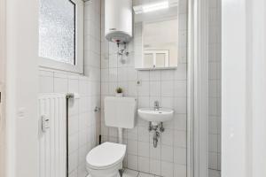 a white bathroom with a toilet and a sink at Apartment mit Balkon in Lünen in Lünen