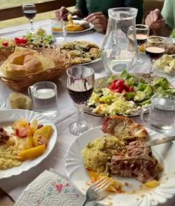 a table with plates of food and glasses of wine at Moonlight House in Vusanje +13 photos