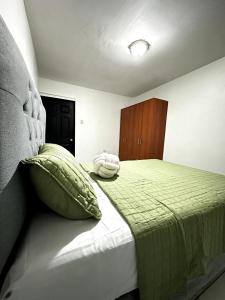 a bedroom with a bed with a green blanket at Casa Privé, Comayagua in Comayagua