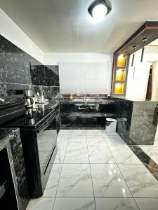 a large kitchen with black and white marble flooring at Casa Privé, Comayagua in Comayagua +3 photos