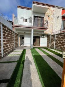 a brick building with a balcony and a lawn at Casa Privé, Comayagua in Comayagua