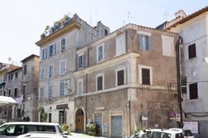 an old building with cars parked in front of it at Luce sul Duomo in Tivoli