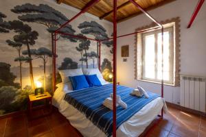 a bedroom with a canopy bed with blue pillows at Luce sul Duomo in Tivoli