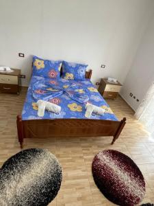 a bedroom with a bed with blue comforter and two rugs at Vila Du Lac Blue in Lin