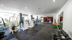 a gym with treadmills and machines in a room at Nura Houses Condor in Playa de Palma
