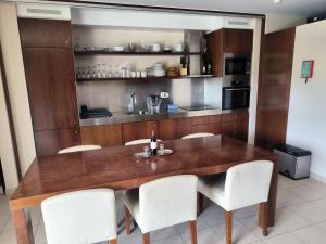 a dining room with a wooden table and white chairs at Salgados Beach&Golf - Praia dos Salgados in Albufeira