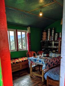 a room with a table and chairs and a table and a window at Green Haven in Kalimpong