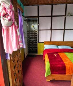 a bedroom with a bed with a colorful blanket at Green Haven in Kalimpong