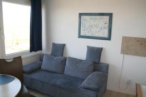 a blue couch in a living room with a window at FW Knütel Nr 59 in Burgtiefe auf Fehmarn 