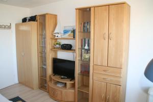 a large wooden book shelf with a television in it at FW Knütel Nr 59 in Burgtiefe auf Fehmarn 