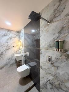a bathroom with a white toilet and a sink at LAGUNA BLU beach villa in Irimbranallūr