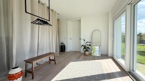 a living room with a bench and large windows at HOUSE CAMELIA - Stilvolles, großzügiges 2-Zimmer-Apartment in Irrel +6 photos