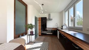 a kitchen with white walls and a large window at HOUSE CAMELIA - Stilvolles, großzügiges 2-Zimmer-Apartment in Irrel