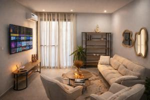a living room with a couch and a table at Dakar Roi - Point E - Modern Studio - Central Location in Dakar