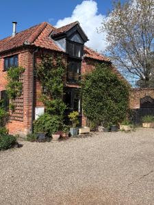 a brick house with plants on the side of it at Roundabout Farm in Thurning