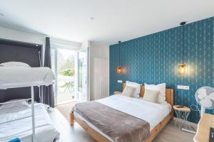 a bedroom with two beds and a blue wall at Le Carre Saint Pierre - Chambres d'hôtes in Marey-lès-Fussey