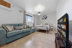 a living room with a couch and a tv and a crib at Private Annex with Gated Driveway near Grove Park Station in Hither Green