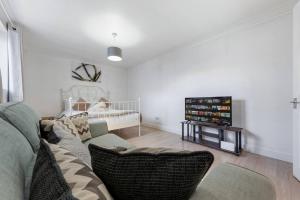 a living room with a couch and a tv at Private Annex with Gated Driveway near Grove Park Station in Hither Green