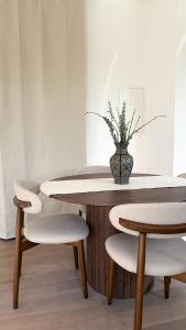 a table with two chairs and a vase with a plant at HOUSE CAMELIA - Stilvolles, großzügiges 2-Zimmer-Apartment in Irrel