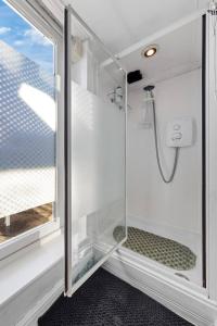 a shower with a glass door next to a window at Private Annex with Gated Driveway near Grove Park Station in Hither Green +17 photos
