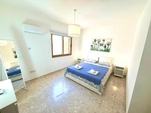 a bedroom with a blue bed and a mirror at Latchi Premium View in Lachi +15 photos