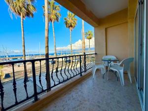 a balcony with a table and chairs and palm trees at Latchi Premium View in Lachi