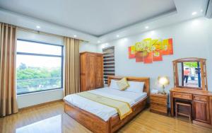 a bedroom with a bed and a mirror and a window at FLC Grand Villa BT31-23 in Sầm Sơn +16 photos