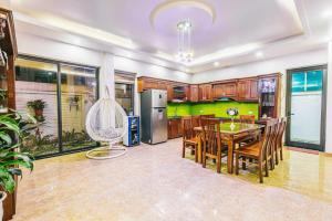 a kitchen and dining room with a table and chairs at FLC Grand Villa BT31-23 in Sầm Sơn