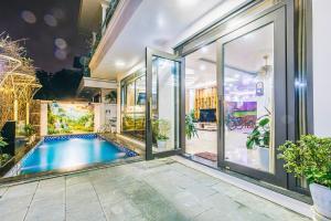 an indoor swimming pool in a house with glass doors at FLC Grand Villa BT31-23 in Sầm Sơn