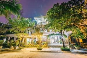 a white house with trees in front of it at FLC Grand Villa BT31-23 in Sầm Sơn