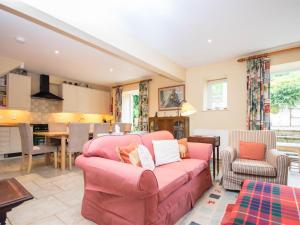 a living room with a pink couch and a kitchen at 4 Bed in Bridport oc-dc195 in Loders