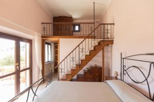 a room with a bed and a spiral staircase at Appartamenti Bellavista by ElbaSummer in Portoferraio