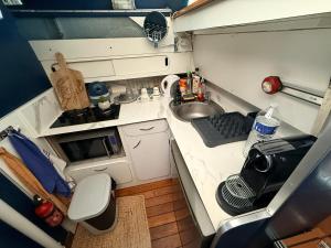 a small kitchen with a sink and a microwave at Aquareve-location in Valence