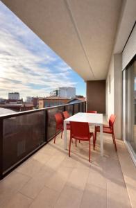 a balcony with a table and chairs on a roof at Woody Green Charming Apartments - Agenzia Cocal in Caorle