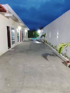 an empty driveway of a white building at night at Cantinho do sol in Maceió