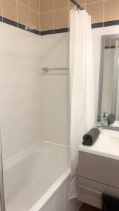a white bathroom with a tub and a sink at Studio détente proche Sanctuaires in Lourdes