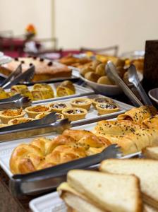 a table filled with different types of bread and pastries at Domus Hotel Torre - Canaã dos Carajás in Canaã dos Carajás